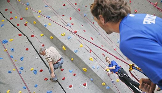 bet36365体育 student climbing the rock wall at the wellness center