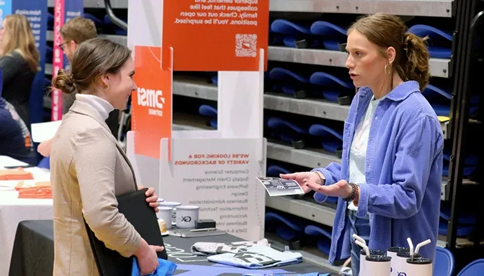 a student speaks with booth attendant at a career and internship fair